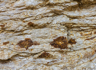 Natural mountain stone, the texture of the site, the walls of a stone canyon in a mountainous area.