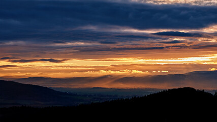 Sunset with dramatic cloudy sky over mountains shape, beautiful nature landscape