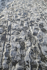 Footprints of pedestrians in the melted snow close-up