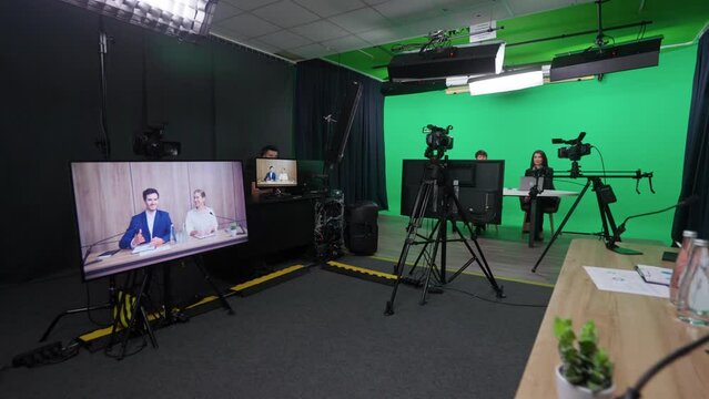 Multicam live broadcast, news anchors at work, view of a backstage studio TV news shooting, chroma key template.