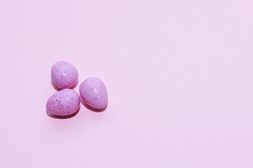 Obraz na płótnie Canvas Purple lavender chocolate easter candy eggs on paper background.
