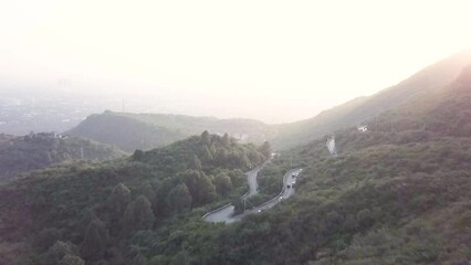Aerial cinematic shot of curve road at  daman e koh . An aerial landscape photography of a city of Islamabad ,the capital of Pakistan