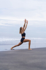 Sporty woman doing mountain climber exercise - run in plank to burn fat. Sunset beach, blue sky...