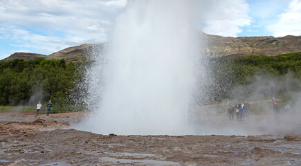 Geysir, Iceland - July 28, 2021: Geyser Strokkur in iceland errupting with hot water and steam, each year many tourists visit the geyser located in the golden circle