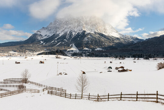 Das winterliche Zugspitzmassiv oberhalb des verschneiten Ehrwalder Beckens in der Morgensonne, Tirol, Österreich