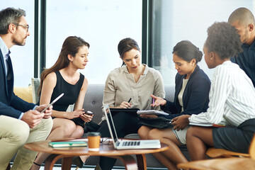Getting down to some serious strategy. Shot of a group of businesspeople discussing work during a...