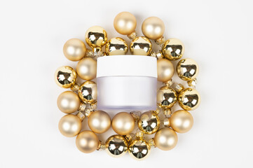 Cream jar on golden Christmas balls podium isolated on white. Top view. flat lay