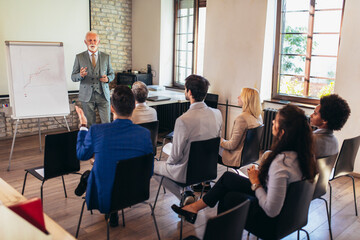 Speaker at business workshop entrepreneur giving a presentation about positive business growth to  colleagues in the office.
