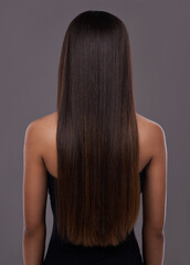 Flawless hair..thanks to her trusty flat iron. Rear view of a young woman with beautiful long hair.