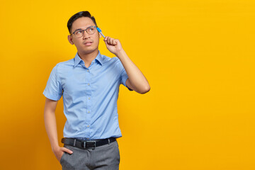 portrait of pensive young asian man in glasses  looking seriously thinking about a question...