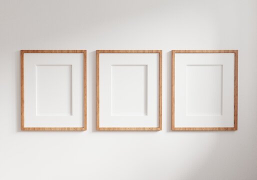 Three empty photo frame for mockup in empty white room. 3D rendering.