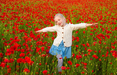 Naklejka na ściany i meble Girl in poppies, happiness and freedom, beautiful spring nature. Happy kid resting on a beautiful poppy field. Child having fun outdoor. Little girl playing in field with red poppies.