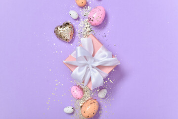 Easter composition with a gift and Easter eggs on a purple background