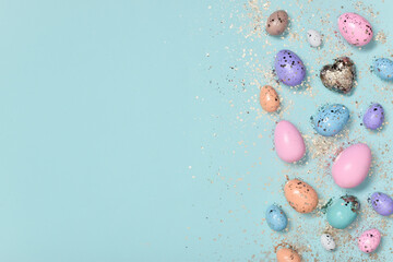 Easter background with painted pastel flowers and glitter Easter eggs.