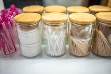 Containers with cotton swabs, tweezers, and brushes for styling eyebrows, accessories for the master of makeup and eyebrows