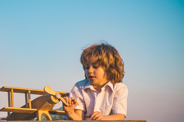 Child boy playing with wooden toy airplane, dream of becoming a pilot. Childrens dreams. Child...