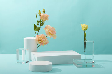 A front view of white and transparent podium decorated with flower and blue background with blank space for advertising  - obrazy, fototapety, plakaty