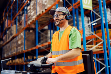 Happy distribution center worker with voice picking headset driving forklift.