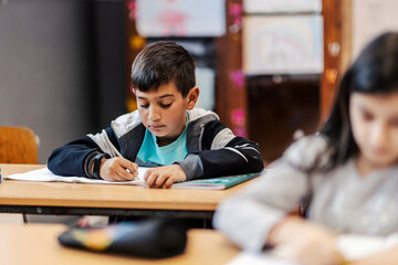 A smart Indian boy solving schoolwork problems at school.