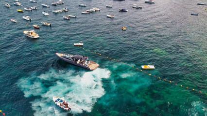 Overhead aerial view of speedboats near the shoreline.