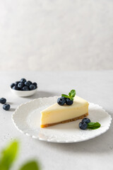 Homemade vanilla cheesecake with blueberry and mint on white background - healthy organic summer dessert pie cheesecake. Cheesecake New York. Side view, copy space. Menu, recipe, confectionery