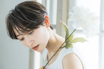 Selbstklebende Fototapeten Friseursalon 白い花を持つ女性ポートレート  © metamorworks