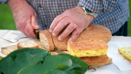 Man cutting bread on a table outdoor