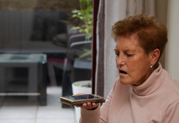 senior woman sending an audio message on the phone