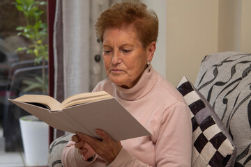 relaxed senior woman reading a book at home