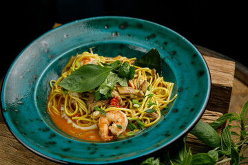 Thai food, noodles in a plate on a wooden table

