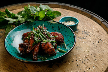 Thai food, chicken legs cooked in sauce in a plate on a wooden table