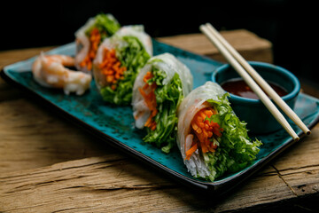 Thai food, grills with rice paper and sauce on a wooden table