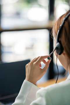 Friendly Female Helpline Operator With Headphones In Call Center