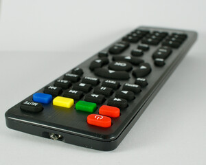TV remote control. Infrared light-operated television, music system, dvd reader, satellite receiver remote control. Isolated on white background. Focus is in the front.