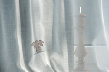Candle light in the interior.Composition of objects on the windowsill.Delicate tulle on the windowsill and holiday items.