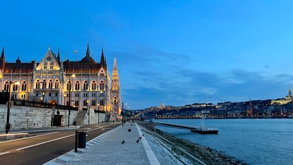 Obraz premium Hungarian Parliament building in Budapest night photography of bright yellow illuminated walls and dark blue sky near the Danube River. High quality 4k footage 03.04.22 Budapest, Hungary