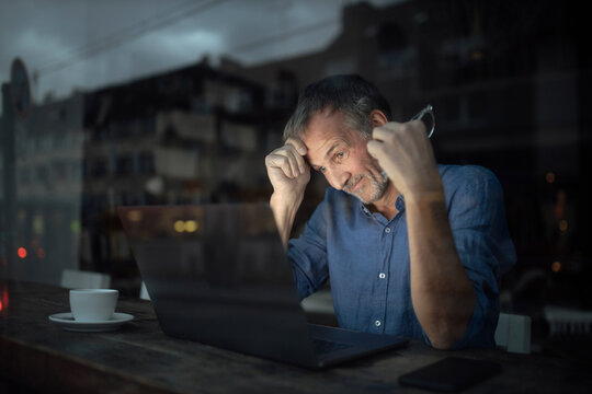 Businessman with laptop working in cafe at night