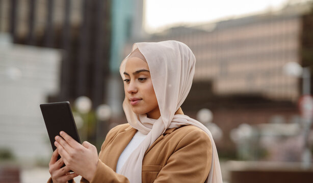 Young businesswoman wearing hijab using tablet PC