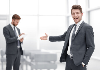 Young businessman invites to his office.