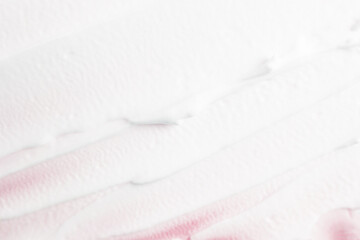 White face cream applied on a pink background. Cosmetic product for skin care, lotion. Texture strokes top view.