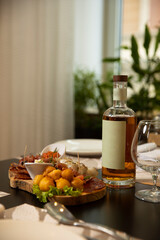 Mockup bottle of whiskey served with food on a restaurant table
