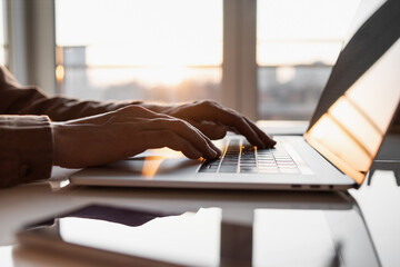 Male hands typing on computer keyboard closeup, business man or student using laptop at home,...