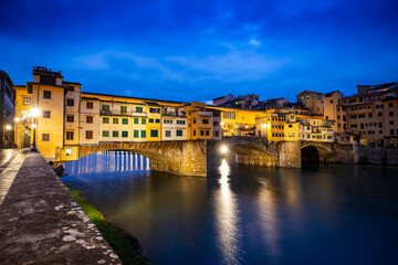 Obraz premium River Arno and famous bridge Ponte Vecchio at sunset from Ponte alle Grazie in Florence, Tuscany, Italy