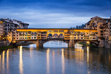 Obraz premium River Arno and famous bridge Ponte Vecchio at sunset from Ponte alle Grazie in Florence, Tuscany, Italy
