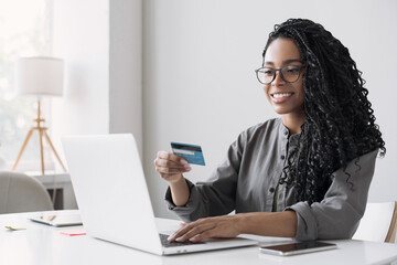 Young woman using laptop computer with credit card making online order. Business, online shopping,...