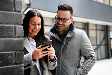Portraite of handsome man and beautiful woman as business partners working talking outdoor