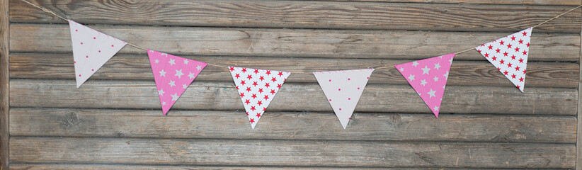 Obraz premium Pennants are placed on colorful flowers, Decorative party pennants, Colorful pennants for celebrations, Bunting and garlands, Carnival garland with flags. Decorative colorful party pennants