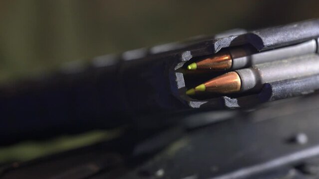 Closeup shot of green-tipped full metal jacket 7.62x39mm bullets loaded in a tactical 30 round capacity polymer magazine for a Kalashnikov AK47 style assault rifle