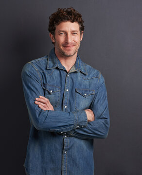 The ladies love a confident man. Studio portrait of a handsome man standing with his arms folded on a gray background.