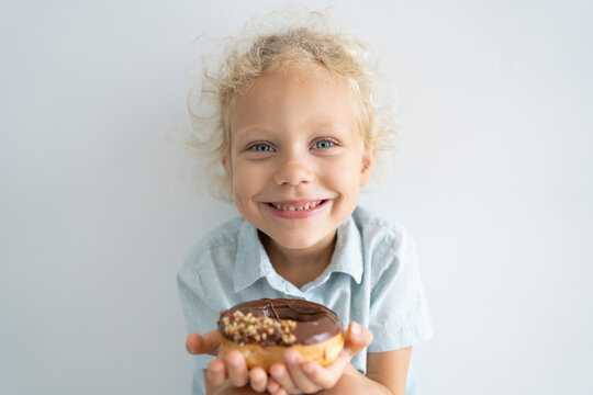 Smiling blond girl holding doughnut